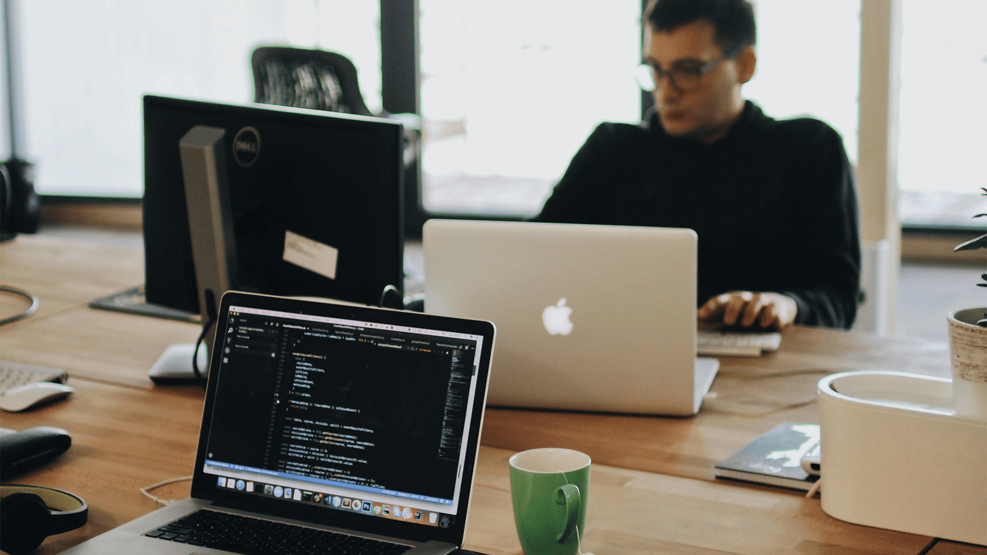 Profesional desarrollando un chatbot con inteligencia artificial para un cliente desde su ordenador en entorno de trabajo empresarial.